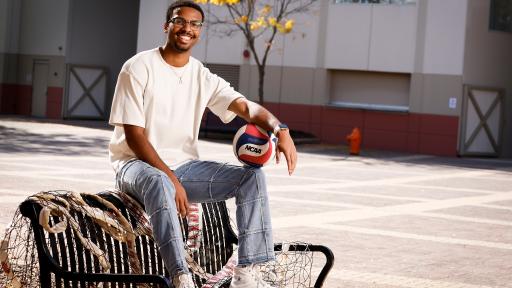 Student sitting on bench with basketball